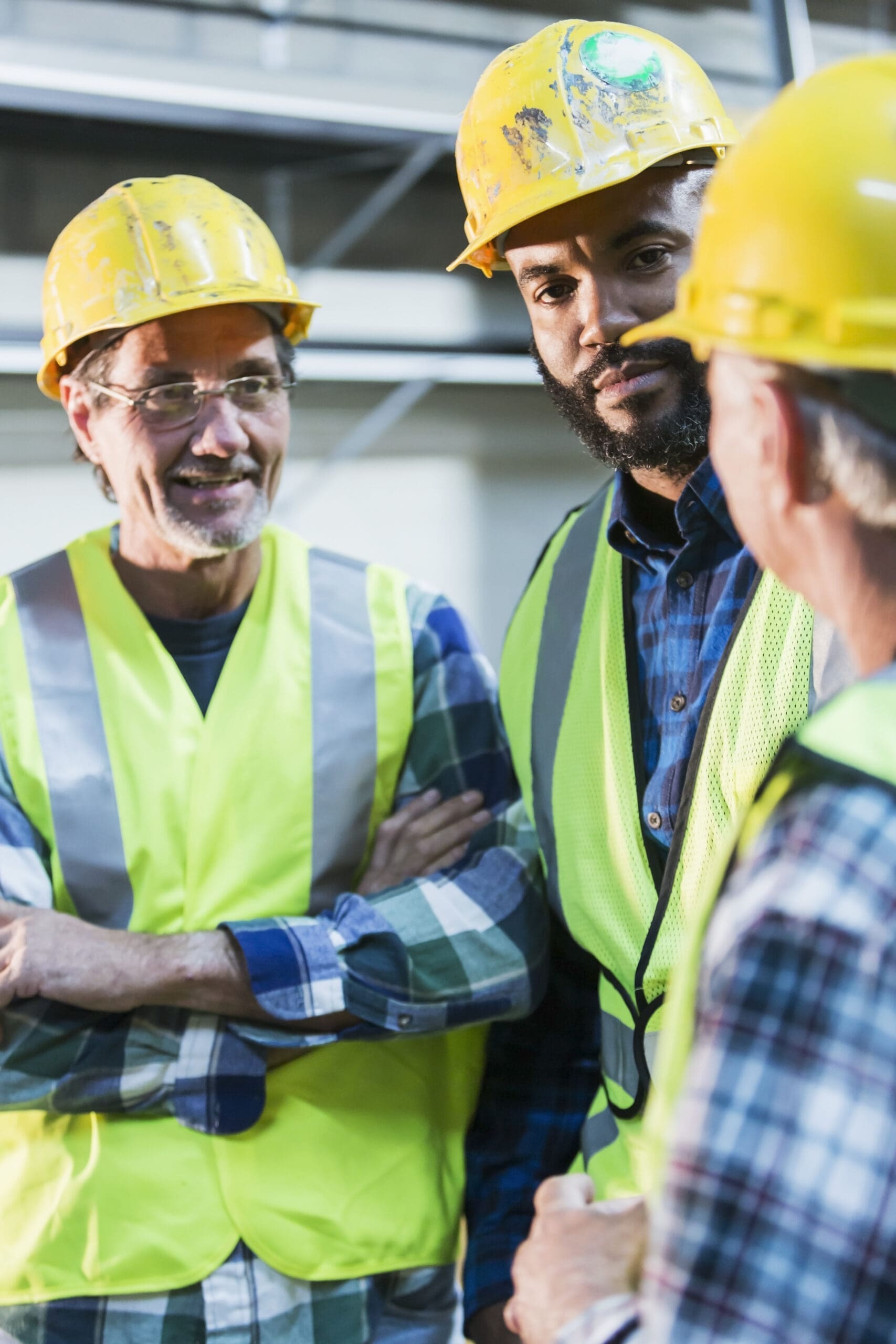 Three workers with safety vests and hard hats